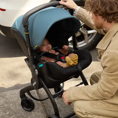 Baby liegt sicher und bequem in ausgeklappter Doona X Babyschale