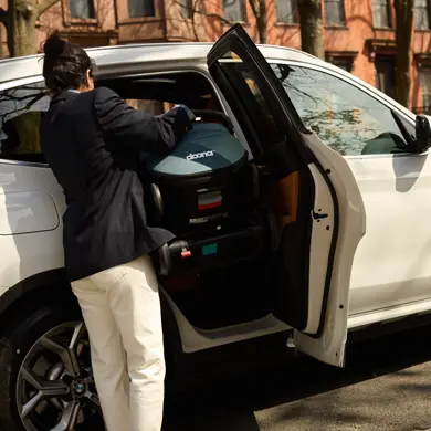 Mama holt die Doona X Babyschale aus dem Auto – schnell einsatzbereit