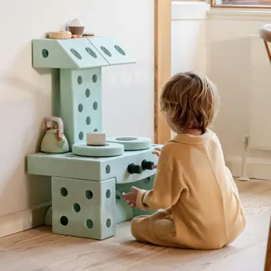 Kind spielt mit Kinderküche gebaut aus dem Modu Dreamer Set Bausteinen
