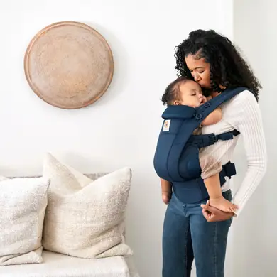 Mama hat schlafendes Baby in der Ergobaby Omni Dream Babytrage