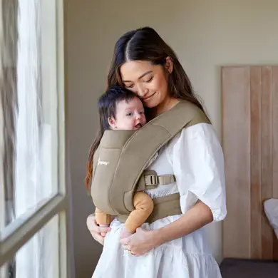 Mama kuschelt mit Baby in der Ergobaby Emrbrace soft Babytrage