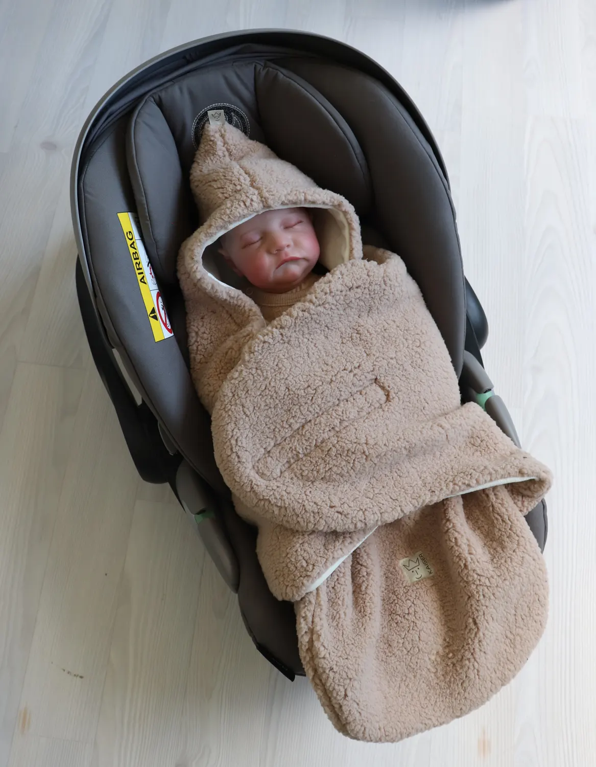 Kaiser Einschlagdecke Sherpa Lifestylebild Kind in Babyschale